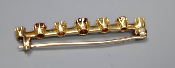 A yellow metal, four stone diamond and three stone ruby set bar brooch, 41mm, gross 3.6 grams.
